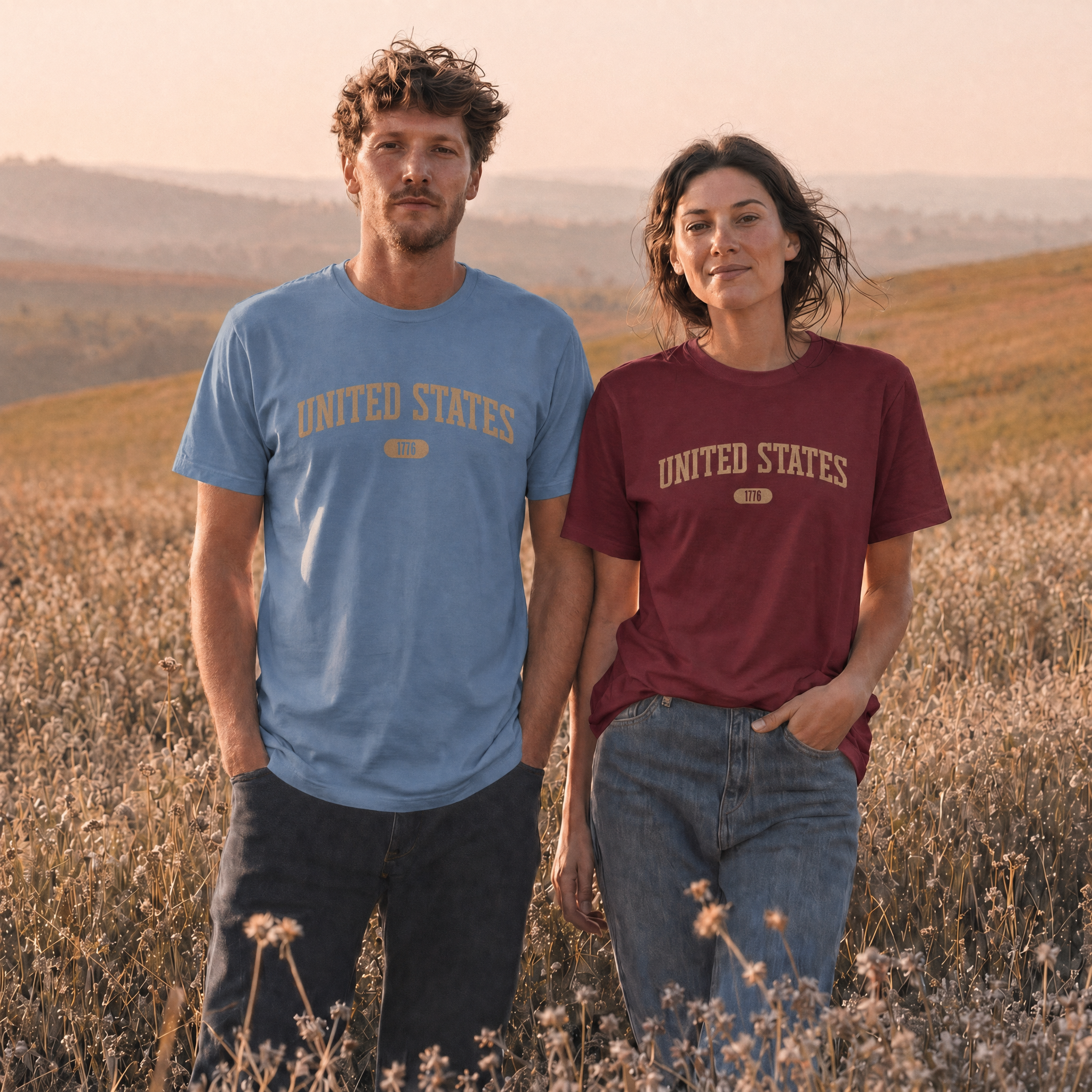 Woman and man wearing tees with 'UNITED STATES 1776' in tan collegiate text standing in a wild flower meadow.