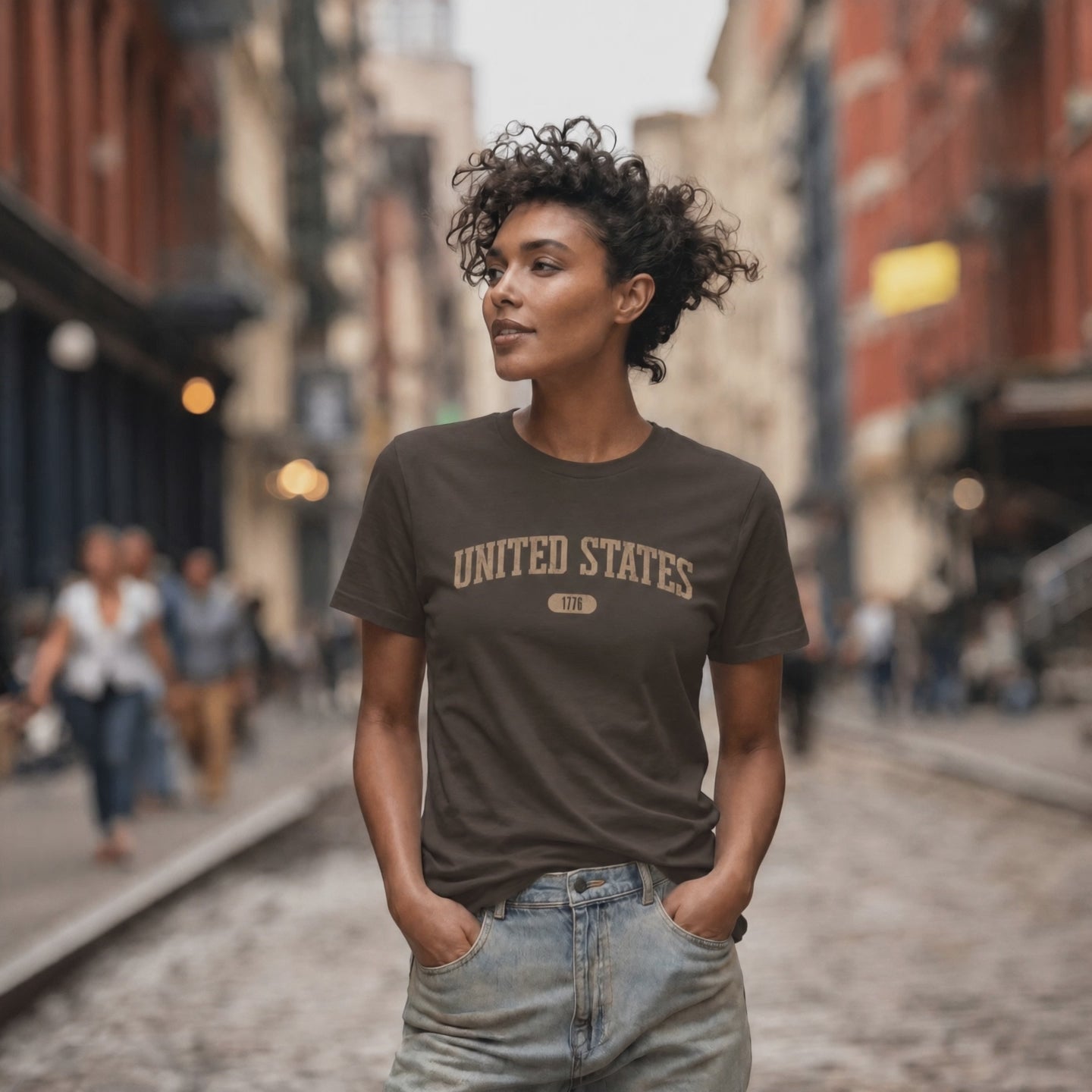 Video of a woman wearing a Heather Maroon t-shirt with 'UNITED STATES 1776' in warm tan collegiate text.
