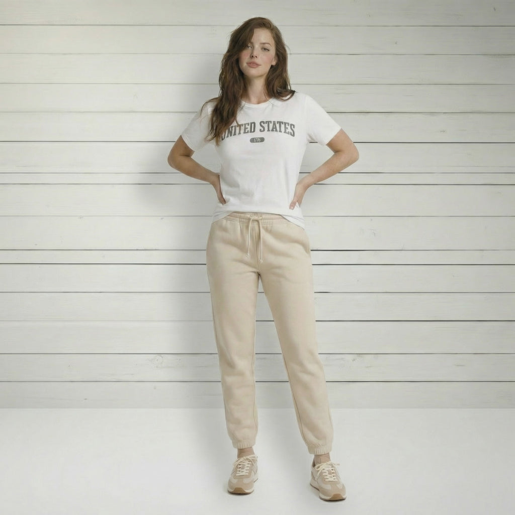 Video of a woman wearing the white t-shirt with 'UNITED STATES 1776' in gray collegiate text.