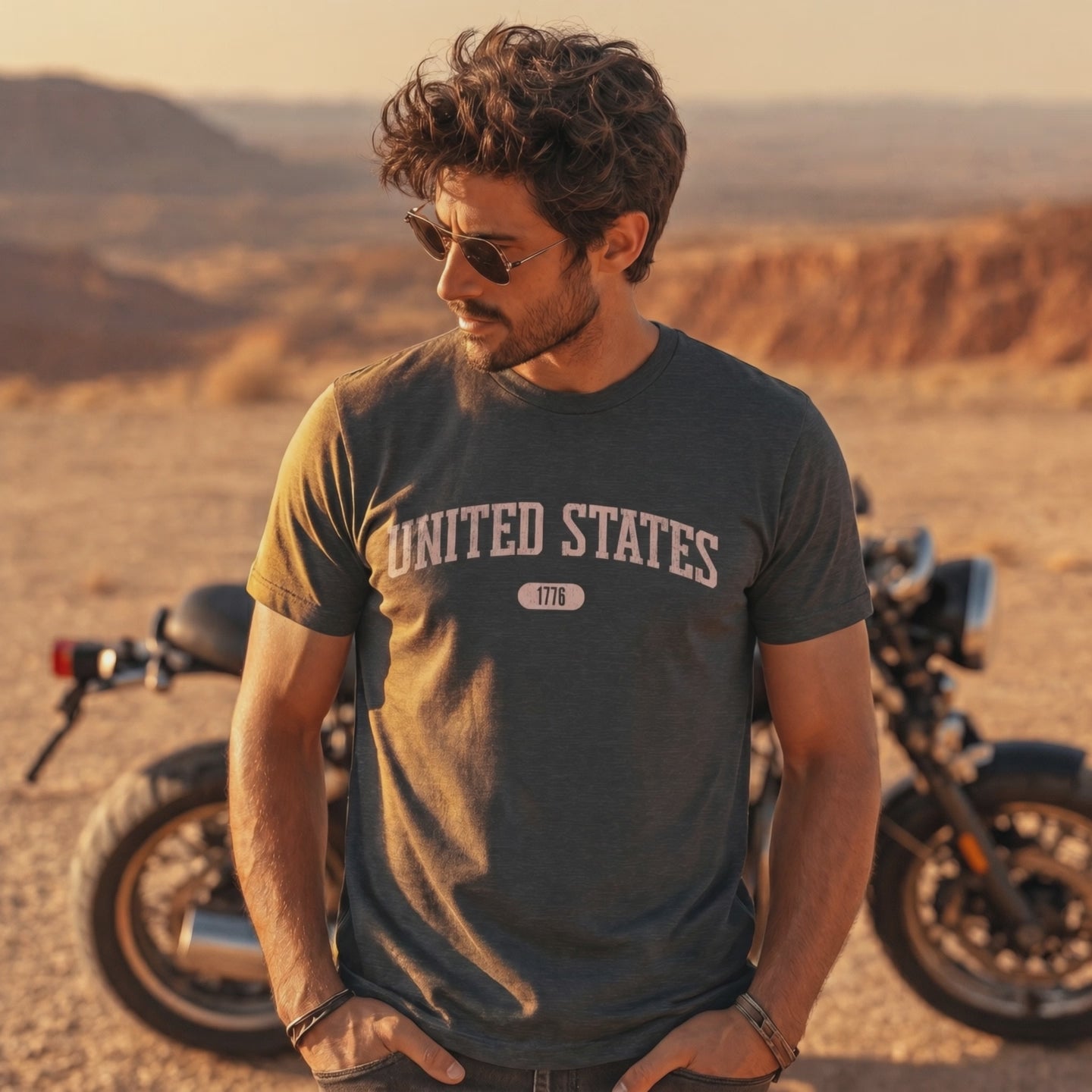 Video of a man wearing a dark gray heather t-shirt with 'UNITED STATES 1776' in pink collegiate text.