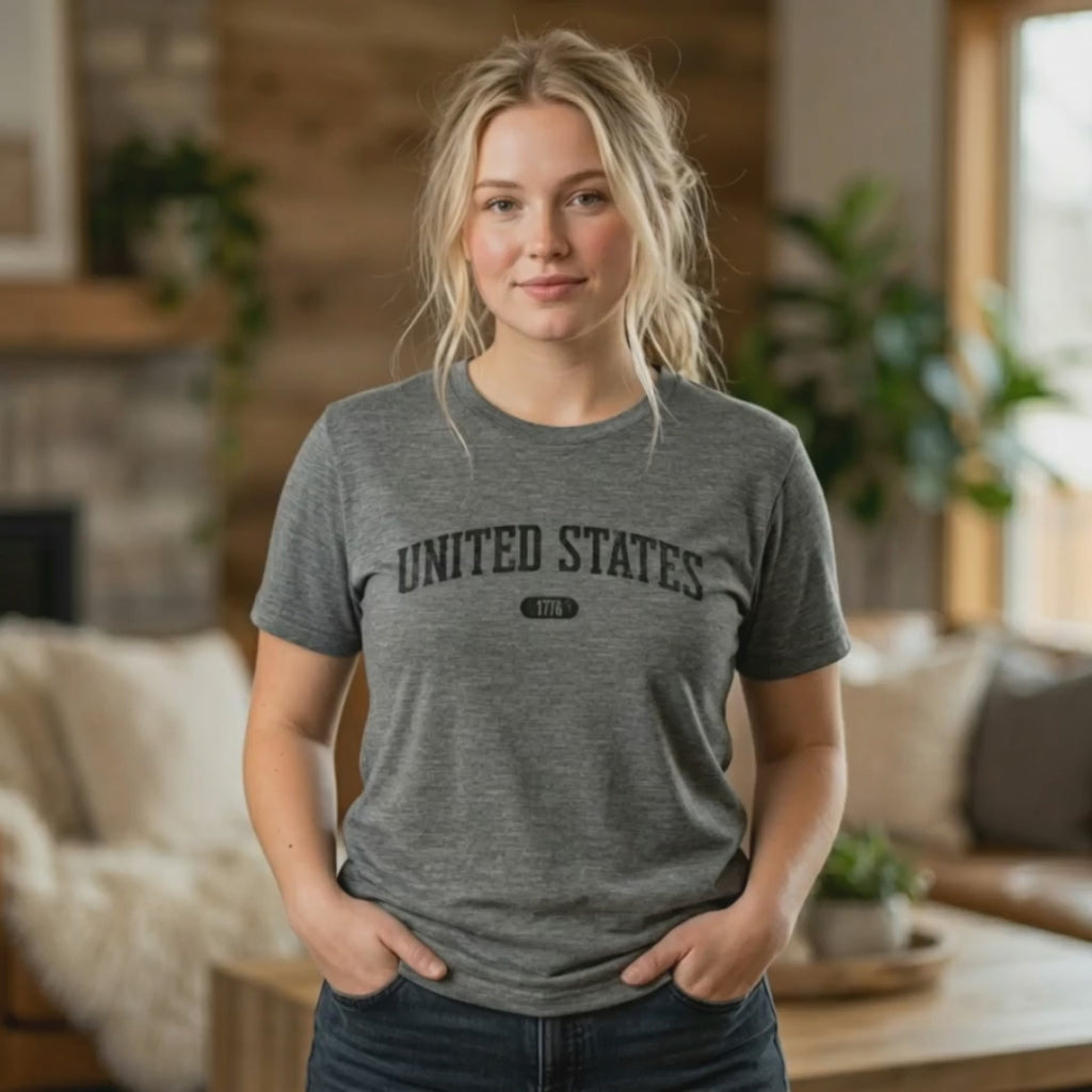 Video of a woman wearing the Deep Heather t-shirt with 'UNITED STATES 1776' in black collegiate text.