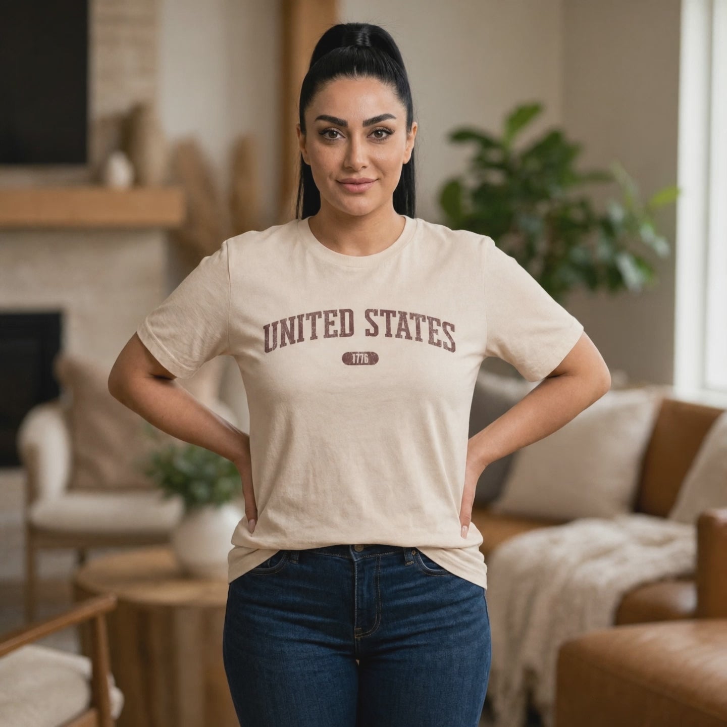 Video of a woman wearing a Soft Cream t-shirt with 'UNITED STATES 1776' in burgundy collegiate text.